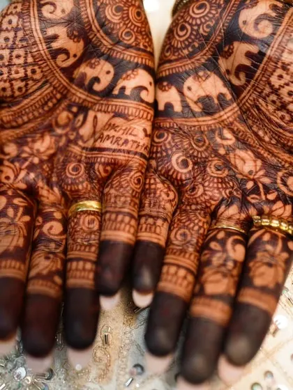 A close-up of the palm, where the names "Akhil" and "Amratha" are written among the patterns.