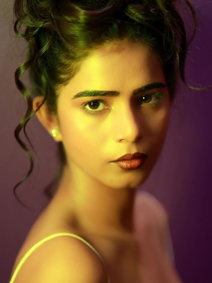 An intense and beautiful close-up. The lighting is warm and dramatic, highlighting her features in a painterly way.