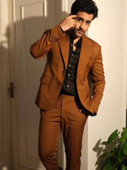 Satyajeet Dubey exudes class in this impeccably tailored brown formal suit. The broad notch lapel and detailed buttonholes bring out the ensemble’s refined artistry.
