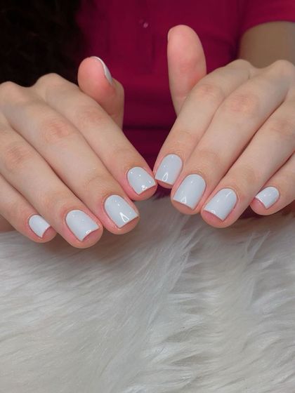 A clean and classic light grey gel polish on short, square nails.