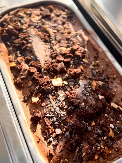 A tray of rich, textured chocolate gelato, showcasing the generous mix-ins. This top-down view emphasizes the quality and richness of our small-batch, handcrafted product.
