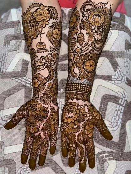 This full-arm design incorporates beautiful hanging jhumka (earring) motifs among the floral and paisley patterns.