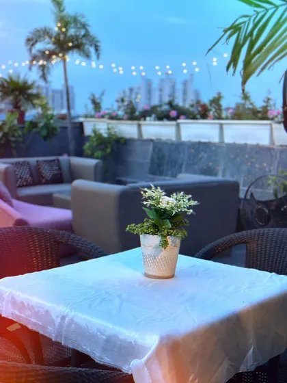A soulful sunset view from the rooftop. The simple table setup allows the stunning colors of the sky and the city view to be the main attraction.