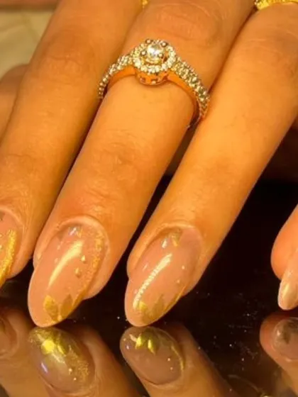 A close-up of the gold foil accent nails, showing the beautiful texture and shine.