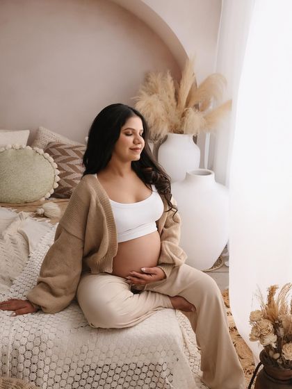 Lost in a moment of peaceful thought, this mom-to-be embodies the calm and beautiful side of pregnancy. The earthy tones of the studio enhance this serene mood.