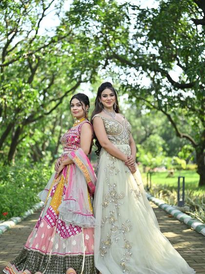 Another beautiful shot of the two models back-to-back, showcasing the full length and design of the elegant gown and the vibrant lehenga.