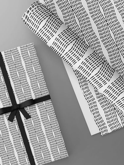 The same abstract line pattern used as gift wrapping paper. The simple, graphic quality of the design, paired with a black ribbon, creates an elegant and sophisticated look for any gift.