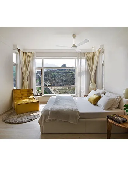 I believe in the power of simplicity to create calm. This minimalist bedroom is designed as a serene sanctuary, using a clean white palette and large windows that frame the natural landscape, proving that sustainable design can be both modern and tranquil.