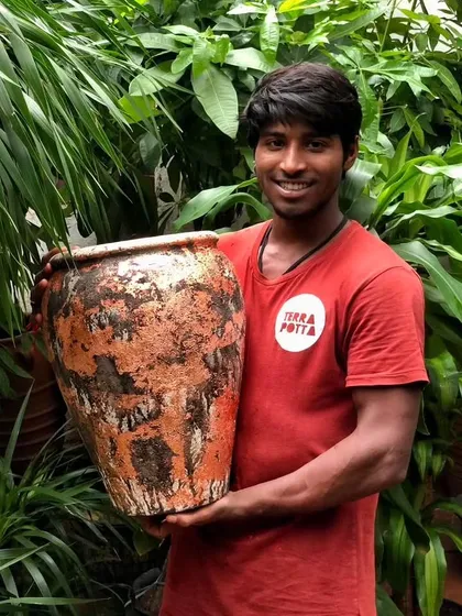 One of our team members proudly holding a piece from our latest range of textured terracotta pots. Each one is a unique, rustic beauty.