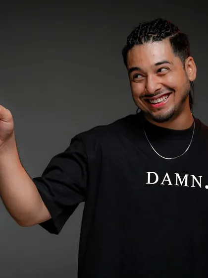 A professional headshot from a Red Bull photoshoot. The shirt says 'Damn.', and the smile says it all. Just spreading smiles and good vibes.