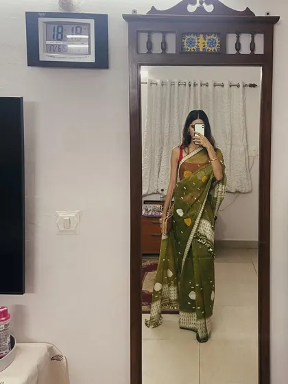 A casual mirror selfie in a lovely olive green jamdani sari. This shows how saris can be a part of everyday festive dressing, not just for grand occasions.