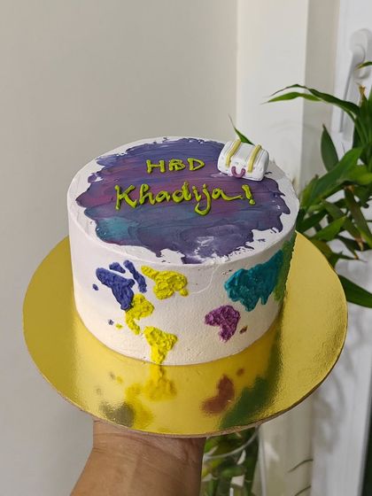 A fun, travel-themed cake for a birthday celebration. I used a watercolor buttercream effect to create a world map on the side of the cake, complete with a tiny suitcase on top.