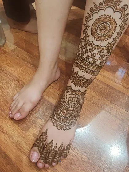 A side view of the full-leg mehendi, showing how the patterns wrap all the way around the leg.