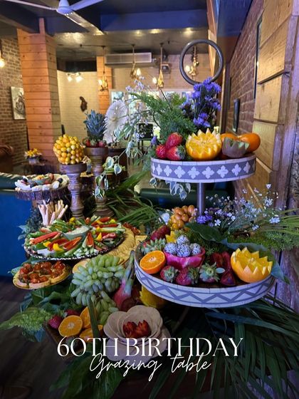 Celebrating a 60th birthday calls for something truly special. This multi-tiered grazing table was filled with an assortment of fresh fruits, vegetable crudités, and gourmet bites, all styled with elegance.