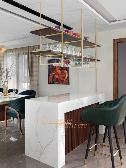 A closer look at the bar area, highlighting the beautiful contrast between the white marble, dark wood, and gold accents of the shelving.