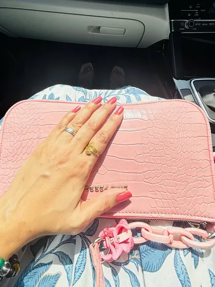 A detail shot of my hand on a pink bag, showing my manicure and rings. This type of content is great for beauty and accessory brands.