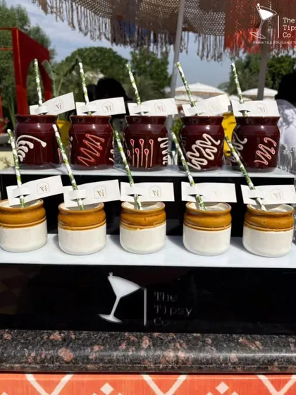 A display of our drinks served in unique jars. The top row features drinks in red jars with chocolate drizzle, while the bottom row uses traditional ceramic 'kulhad' cups.