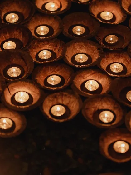 A cluster of floating candles in coconut shells, ready to be released onto the lagoon by guests after the Varmaala. This interactive ritual symbolizes the collective blessings for the couple's new journey.