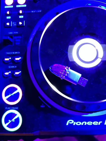 My custom Frostbite USB plugged into the Pioneer DJ deck, glowing under the club lights. A perfect symbol of my two passions, music and design, coming together.