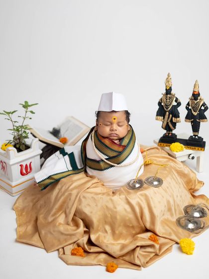 A beautiful composition of the Warkari theme, with the baby, idols, Tulsi plant, and other devotional items arranged perfectly.