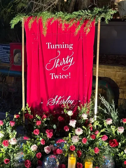 My signage is often the first thing guests see, setting the tone for an event. I loved designing this minimal yet dramatic acrylic sign for a 60th birthday, where my calligraphy popped against the rich red backdrop, disco balls, and lush florals.