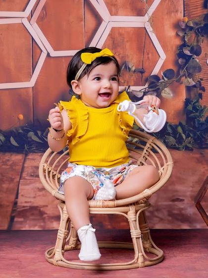 A joyful first birthday celebration with a honeycomb and sunflower theme. This little girl's happy expression says it all!