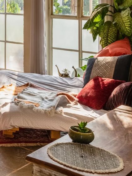 A close-up of the cozy daybed, surrounded by plants and bathed in natural light. It’s a perfect example of the small pockets of joy we design into our homes.