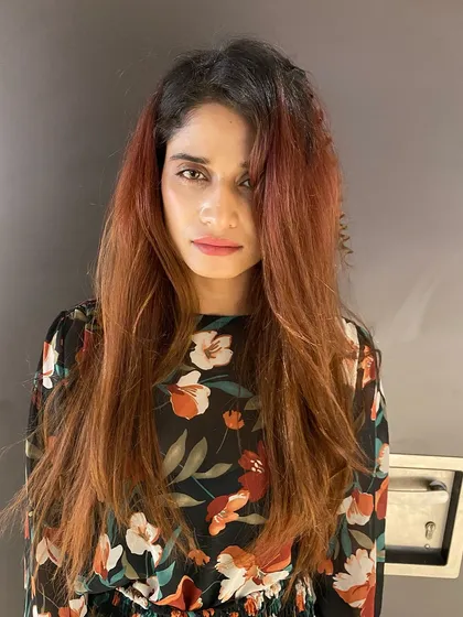 This is the "before" shot of a major color correction. The hair was previously colored and had faded into an uneven, brassy red-orange tone.