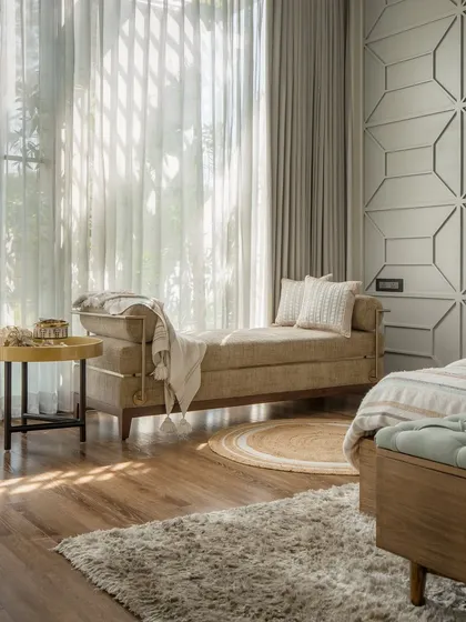 A serene bedroom corner with a comfortable daybed, perfect for reading or enjoying the view. The textured wall paneling and soft, natural light create a peaceful and relaxing atmosphere.