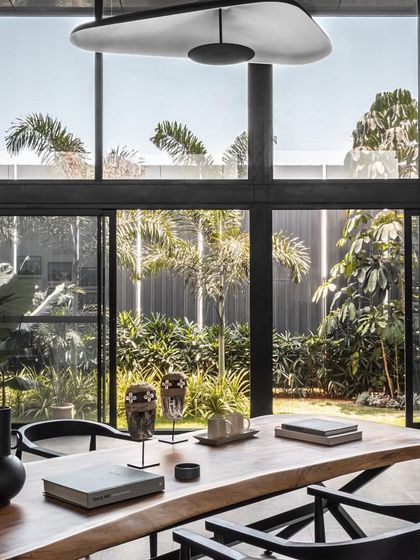 The main meeting table is set against floor-to-ceiling windows, allowing for meetings to be conducted in a light-filled space with views of the garden.