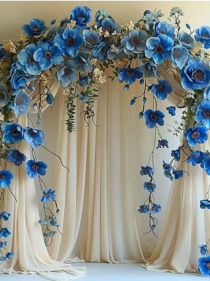 A breathtaking floral arch made of cascading blue flowers over a sheer curtain, perfect for a wedding ceremony or an elegant photo booth.
