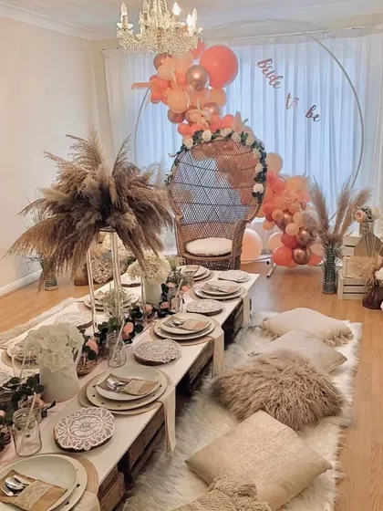 A look at our boho-chic bridal shower setup, designed to be effortlessly beautiful. We combine low wooden tables, plush floor cushions, and arrangements of pampas grass with a statement wicker chair for the bride-to-be, creating a picture-perfect celebration.