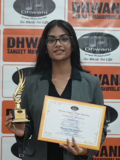 A student proudly holds her certificate and award for excellence in art.