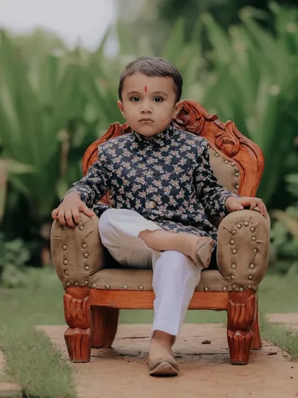 Beyond the candid shots, I also craft classic portraits. This little gentleman, dressed in a traditional kurta, looks so poised on this miniature throne. It shows a different kind of *nazakat* or grace that I love to find in every child.