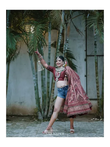 A playful and confident bridal portrait, capturing the bride's fun personality as she poses in her wedding jewelry and shorts.