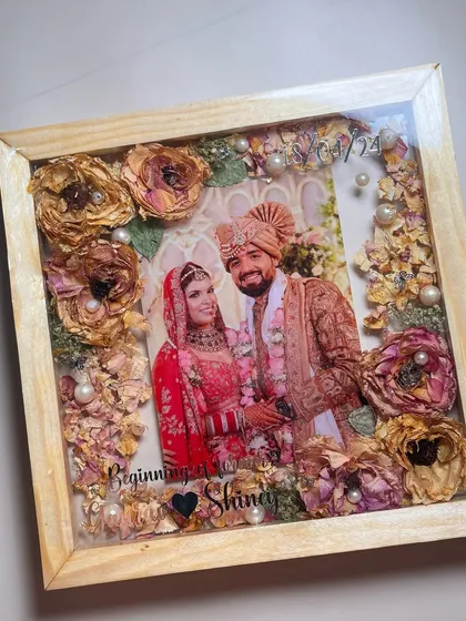 Your wedding memories, beautifully displayed. I preserved this couple's varmala and wedding photo in a classic wooden shadow box frame. The flowers are carefully arranged to create a stunning 3D effect, making it a perfect centerpiece for your wall.