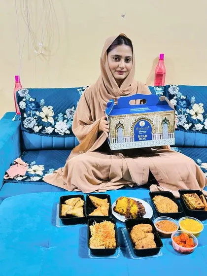 A happy customer with her complete Iftar feast spread out at home. Our boxes are designed to be a convenient and delicious way to enjoy your meal without the stress of cooking.