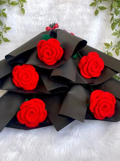 A closer look at the bunch of single red roses, each in its own black paper wrapping. They look so striking together.