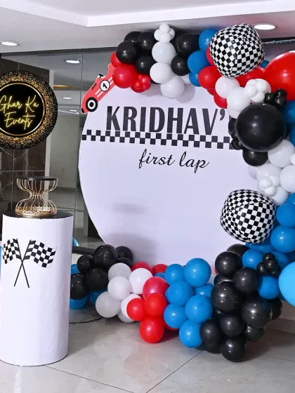 Another angle of the "First Lap" race car theme. The dynamic balloon garland with pops of red and blue perfectly complements the black and white checkered flag motif.