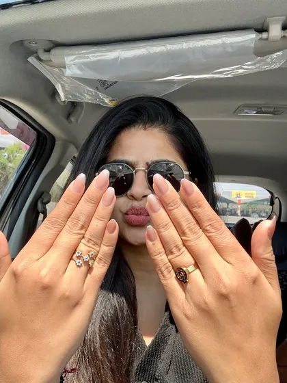 A happy client showing off her fresh, natural-looking manicure with a subtle French tip. It's a versatile look that's perfect for everyday confidence.