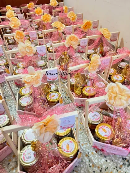 An overhead view of the 65 Haldi hampers, showing the beautiful arrangement of pink and yellow flowers and personalized tags.