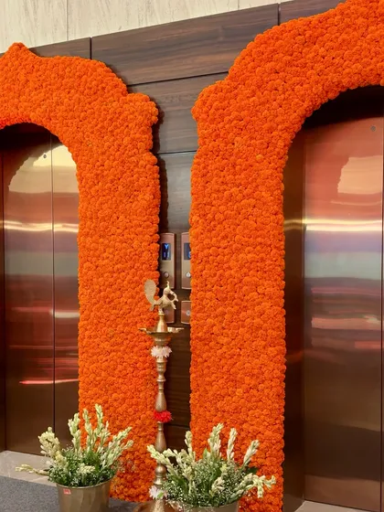 A close-up of the dense marigold flower arch, showcasing the texture and vibrant color that brings so much energy and tradition to a wedding entrance.