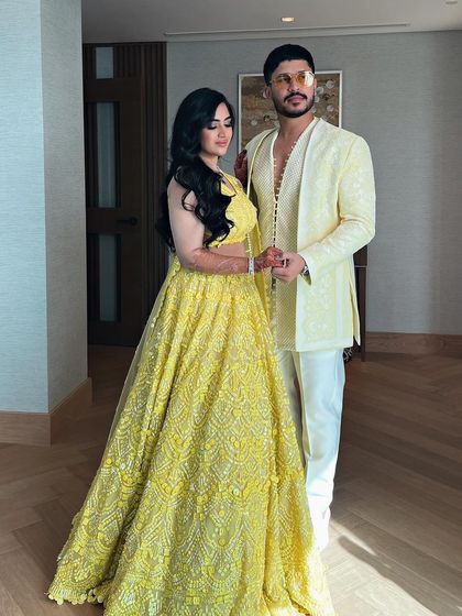 The couple's full look, with the bride's long, flowing waves adding to the romance.