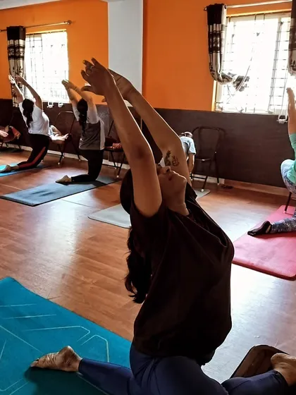 This image captures the full expression of the supported lunge, showing how chair yoga can still be a dynamic and challenging practice that improves flexibility and posture.