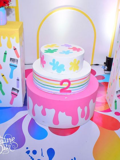 The cake display for the art-themed party. The cake itself is decorated with paint splatters, and the entire setup is designed to look like a colourful art installation.