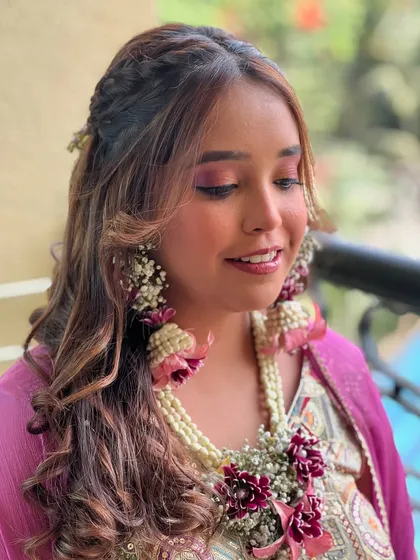 A lovely Mehendi look featuring soft pink makeup and beautiful floral jewellery.