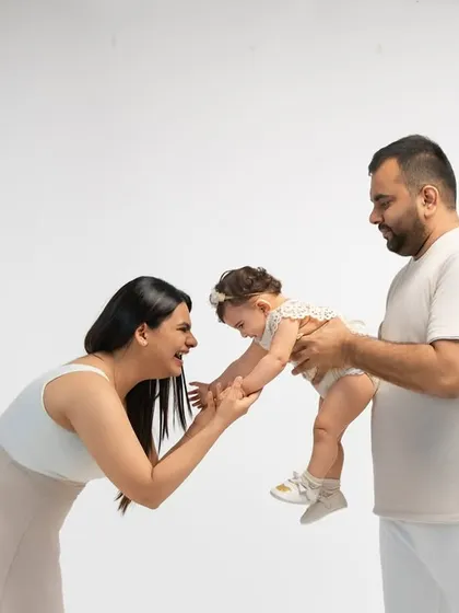 A sweet family interaction as a mother reaches for her baby held by her father. These are the unposed, in-between moments that tell the real story of your family.