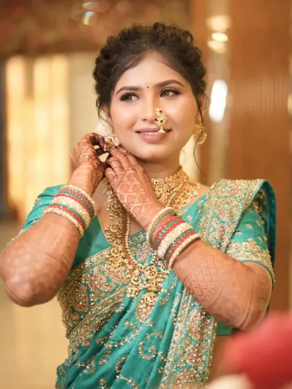 Another beautiful shot of the bride adjusting her earring, her smile lighting up the frame.