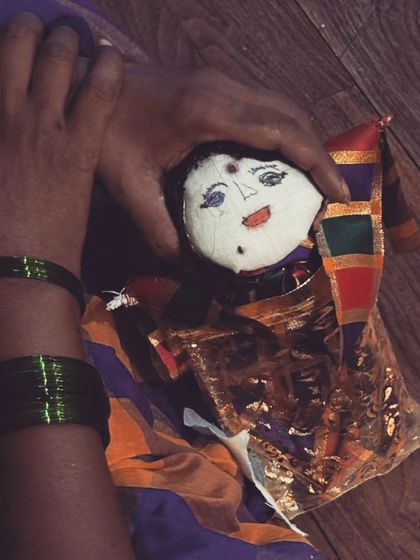 A participant holds a doll made during an inner child workshop. These dolls are not just crafts; they are vessels for stories, lullabies, and hope.