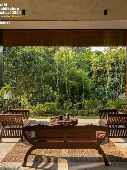 A tranquil outdoor seating area is surrounded by dense bamboo, creating a private and serene retreat.